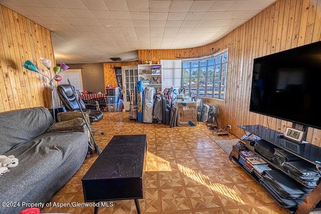 living room featuring parquet floors and wooden walls