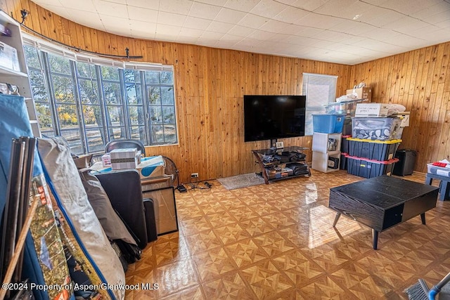 living room featuring parquet floors and wooden walls