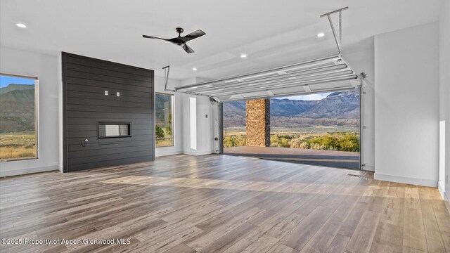 63 Meadow Creek Ct, Battlement Mesa, CO 81635 - unfurnished living room with a mountain view, baseboards, recessed lighting, wood finished floors, and ceiling fan