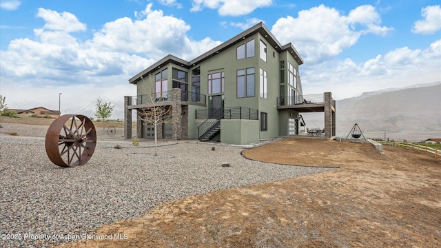 63 Meadow Creek Ct, Battlement Mesa, CO 81635 - back of property featuring a deck with mountain view, a balcony, stucco siding, driveway, and a patio