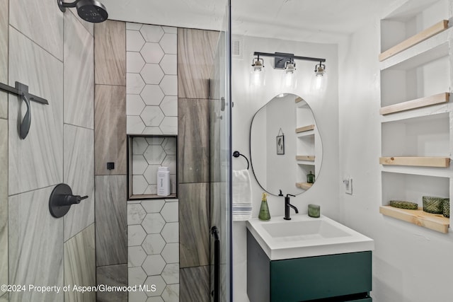 bathroom featuring vanity, tiled shower, and built in shelves