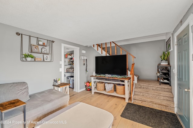 living room featuring wood-type flooring and a textured ceiling