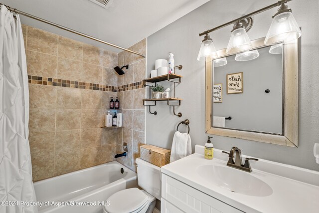 full bathroom with vanity, shower / bath combo, and toilet