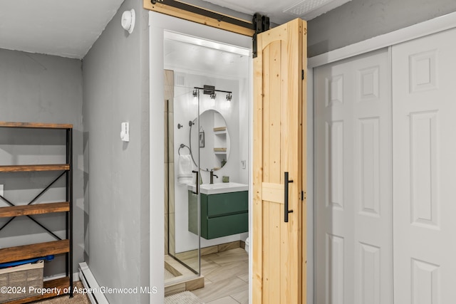 bathroom with vanity, a shower with shower door, and baseboard heating