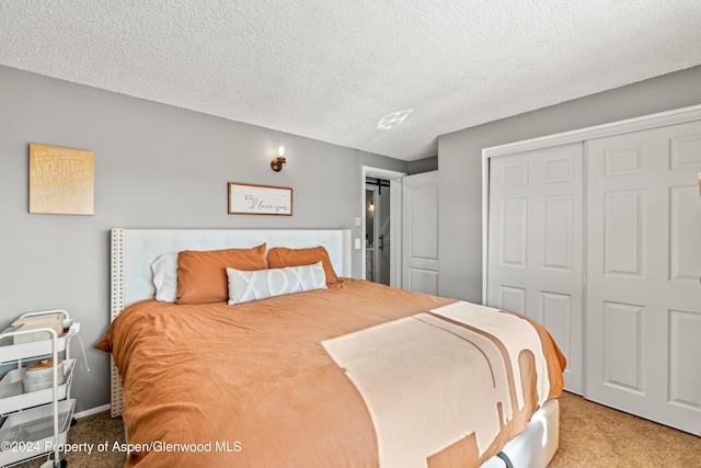 bedroom with light colored carpet, a textured ceiling, and a closet