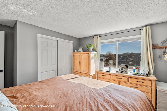 bedroom with a textured ceiling and a closet