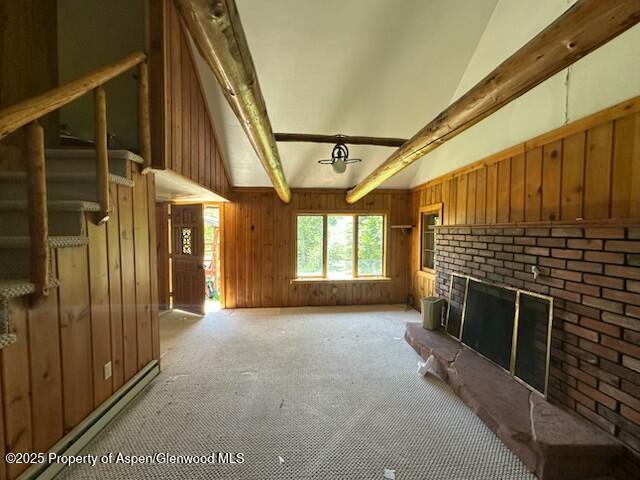 15405 Frying Pan Rd, Basalt, CO 81621 - unfurnished living room with light colored carpet, wood walls, a brick fireplace, beam ceiling, and high vaulted ceiling