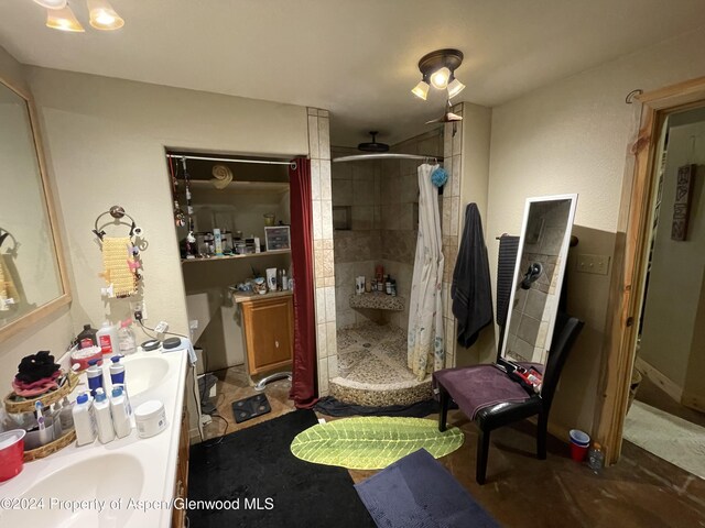 bathroom with a shower stall, ceiling fan, and vanity