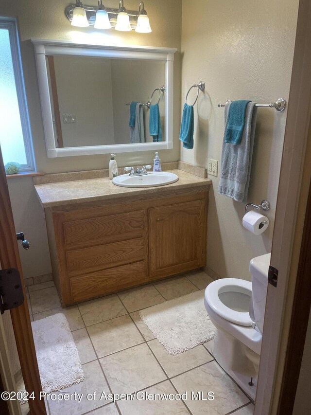 bathroom featuring toilet, vanity, and tile patterned floors