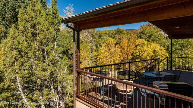 balcony featuring a forest view and area for grilling