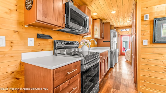 329 River Frontage Rd # 14, Silt, CO 81652 - kitchen with appliances with stainless steel finishes, wood walls, light wood finished floors, a sink, and light countertops