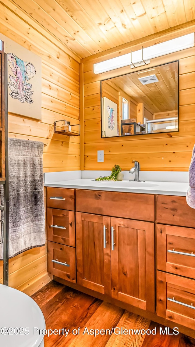 329 River Frontage Rd # 14, Silt, CO 81652 - bathroom featuring wooden walls, wooden ceiling, wood finished floors, vanity, and toilet