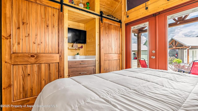 329 River Frontage Rd # 14, Silt, CO 81652 - bedroom featuring a barn door, access to outside, and wooden walls