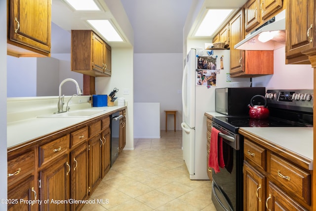 kitchen with electric stove, brown cabinets, light countertops, a sink, and under cabinet range hood