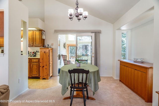 dining space featuring light tile patterned floors, light carpet, baseboards, vaulted ceiling, and an inviting chandelier