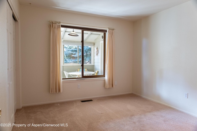 carpeted empty room featuring visible vents and baseboards