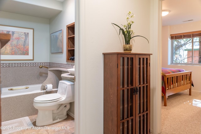 full bathroom featuring toilet, visible vents, tile patterned flooring, and a bath