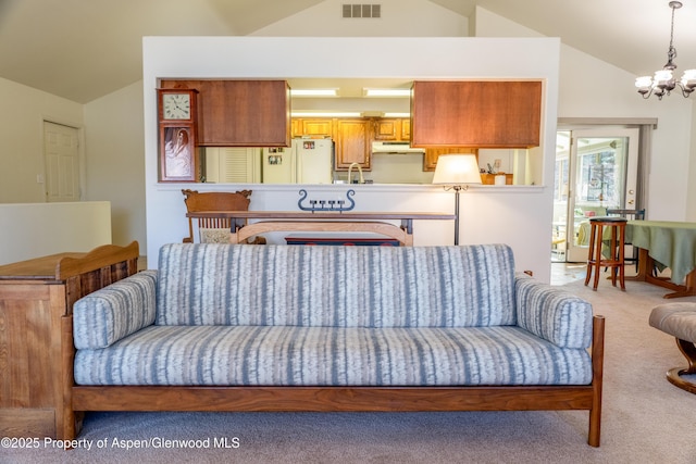 living area featuring carpet floors, visible vents, a notable chandelier, and lofted ceiling