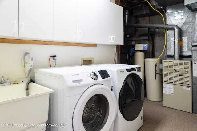 clothes washing area featuring separate washer and dryer, a sink, and cabinet space