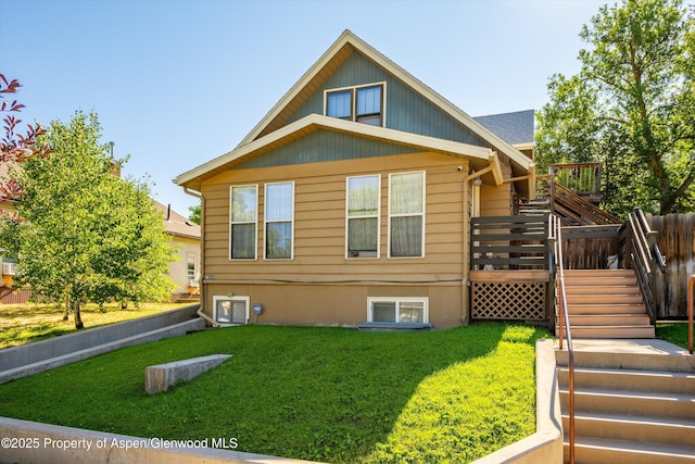 rear view of property with a yard and a wooden deck