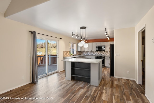 721 Pine Ct, New Castle, CO 81647 - kitchen with light countertops, backsplash, a center island, stainless steel appliances, and dark wood-type flooring