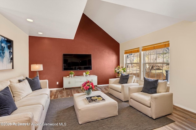 721 Pine Ct, New Castle, CO 81647 - living area featuring baseboards, vaulted ceiling, wood finished floors, and an accent wall