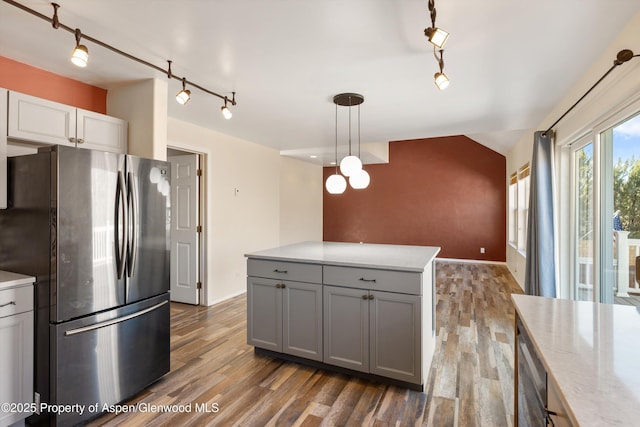 721 Pine Ct, New Castle, CO 81647 - kitchen with pendant lighting, freestanding refrigerator, wood finished floors, gray cabinetry, and lofted ceiling