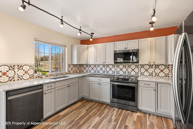 721 Pine Ct, New Castle, CO 81647 - kitchen with light countertops, a sink, light wood finished floors, appliances with stainless steel finishes, and decorative backsplash