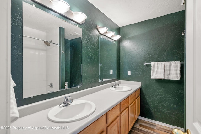 721 Pine Ct, New Castle, CO 81647 - bathroom with a textured wall, double vanity, a sink, and wood finished floors