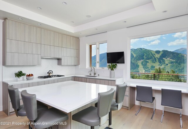 kitchen featuring a kitchen bar, a center island, gas cooktop, and sink