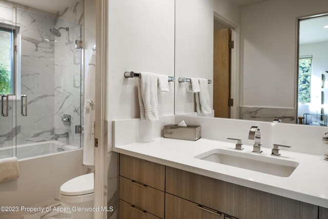 full bathroom with shower / bath combination with glass door, vanity, and toilet