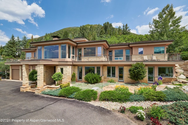 view of front of property with a mountain view and a balcony