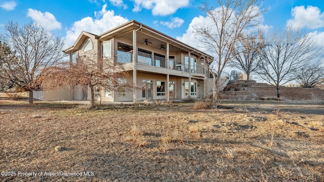 rear view of house with ceiling fan and a balcony