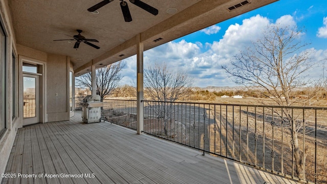 wooden terrace with area for grilling and ceiling fan