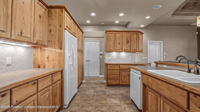 kitchen featuring sink, white appliances, tile patterned flooring, and tasteful backsplash