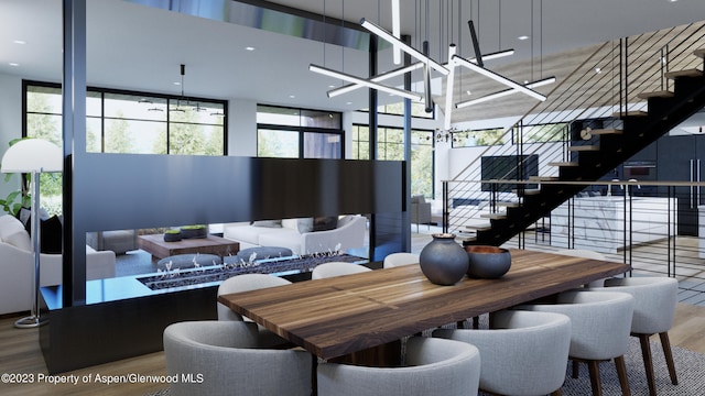 dining room featuring plenty of natural light, a towering ceiling, and wood-type flooring