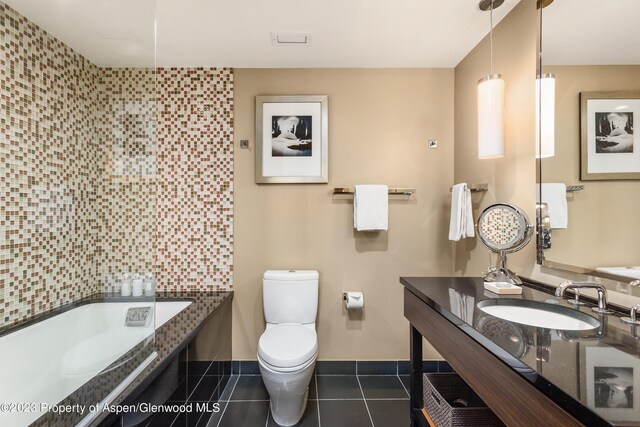 bathroom featuring backsplash, a bathtub, sink, tile patterned flooring, and toilet