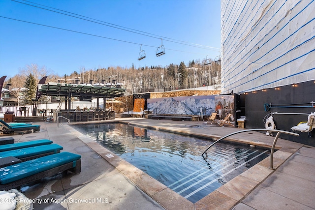 snow covered pool with a patio area