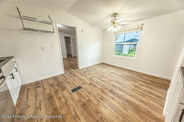 261 Ellis Ave, Maybell, CO 81640 - unfurnished dining area featuring light wood finished floors, ceiling fan, visible vents, vaulted ceiling, and baseboards
