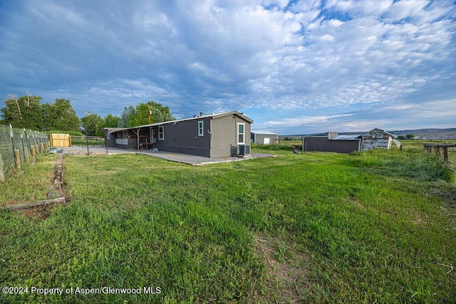 261 Ellis Ave, Maybell, CO 81640 - back of house featuring an outdoor structure, a yard, fence, a patio, and a shed