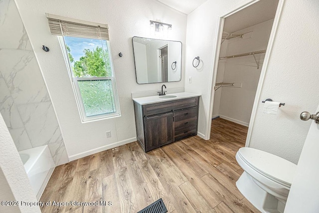 261 Ellis Ave, Maybell, CO 81640 - full bathroom with wood finished floors, toilet, a walk in closet, vanity, and baseboards