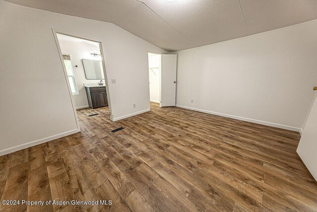 261 Ellis Ave, Maybell, CO 81640 - spare room with a textured ceiling, visible vents, baseboards, vaulted ceiling, and wood finished floors