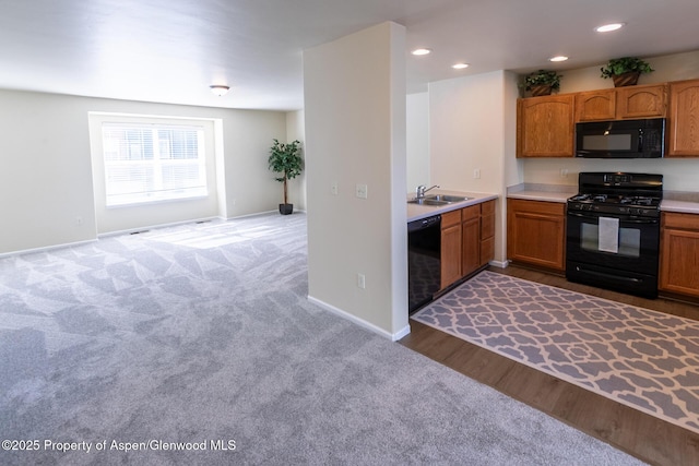 2449 Pine Ln, Rifle, CO 81650 - kitchen with black appliances, carpet flooring, a sink, light countertops, and baseboards