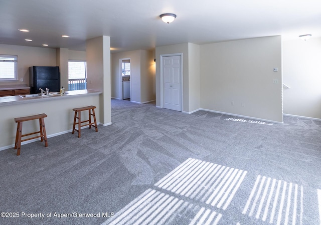 2449 Pine Ln, Rifle, CO 81650 - unfurnished living room with carpet floors, baseboards, and a sink