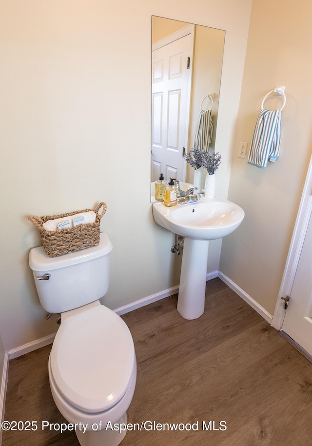 2449 Pine Ln, Rifle, CO 81650 - half bathroom with baseboards, toilet, and wood finished floors