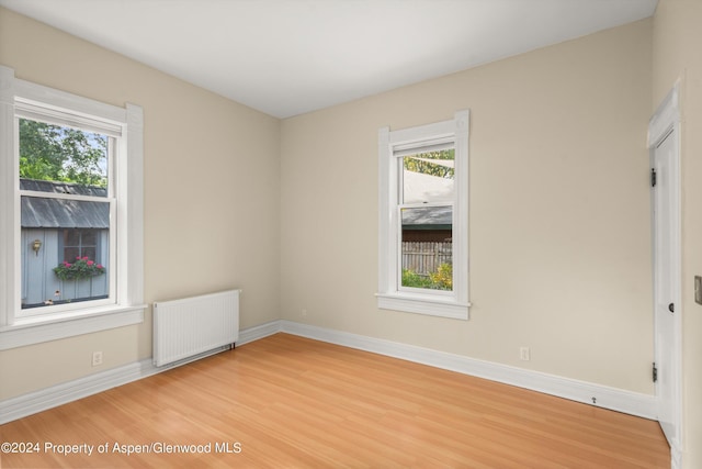 spare room with radiator and hardwood / wood-style floors