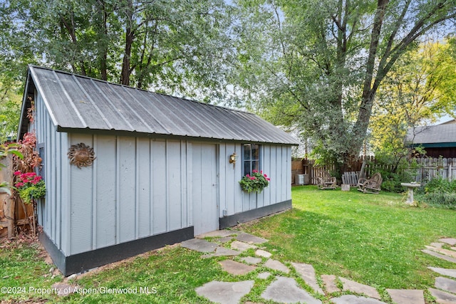 view of outbuilding featuring a lawn