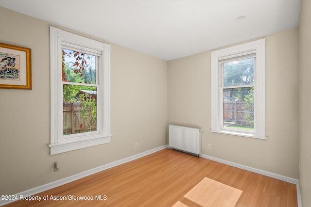 spare room with radiator and light hardwood / wood-style floors