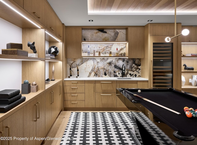 interior space featuring light countertops, a sink, decorative backsplash, and open shelves