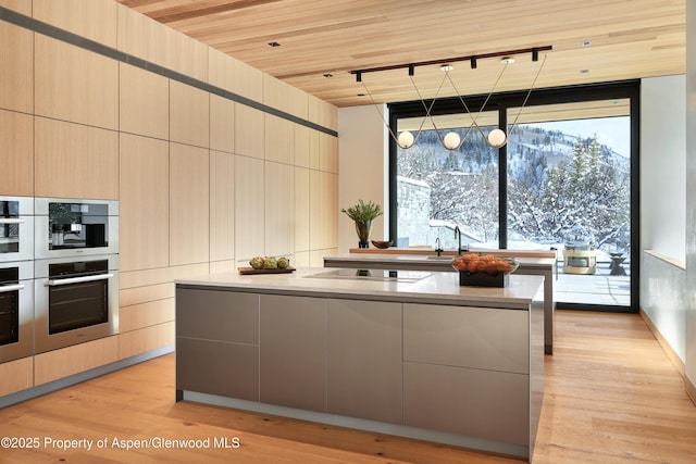 kitchen featuring wood ceiling, floor to ceiling windows, light wood-style flooring, and modern cabinets